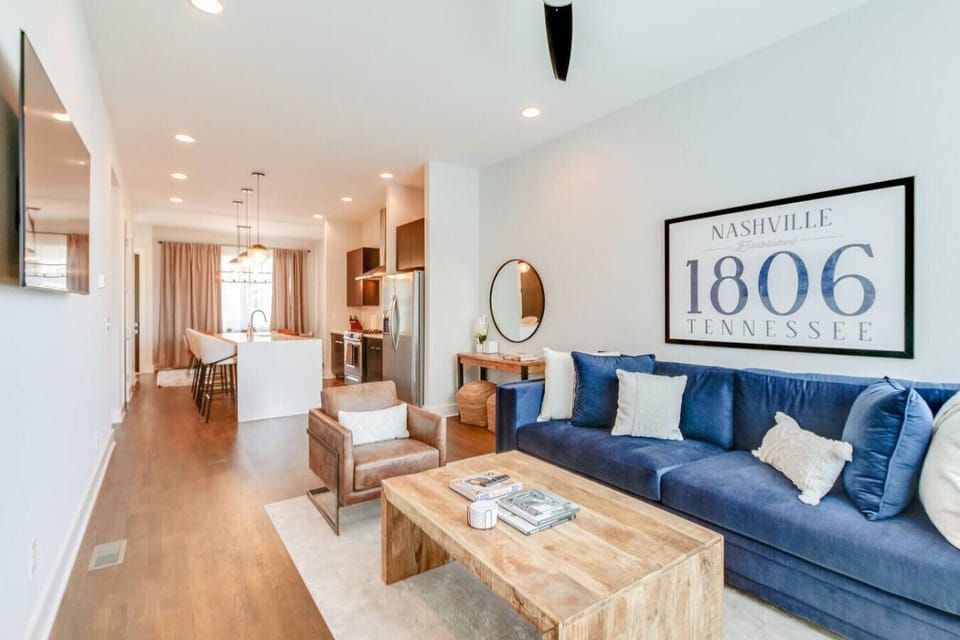 The perfect spot to unwind and recharge — a bright living room with a blue sofa and local art