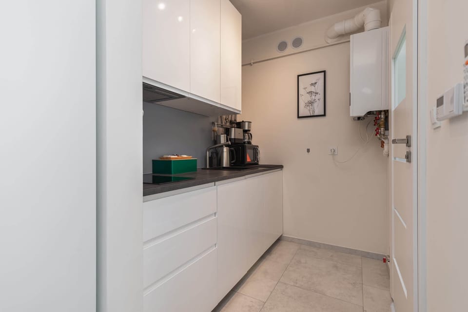 The kitchen's sleek design includes all necessary cookware and utensils. 