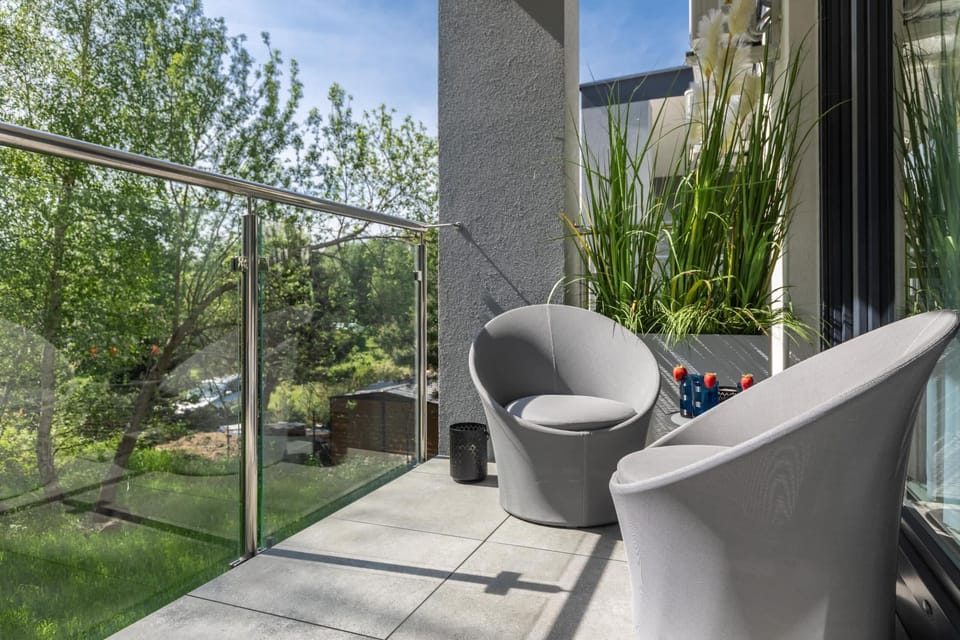 Furnished balcony with green surroundings. 