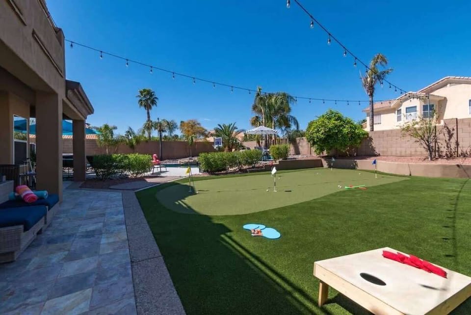 Your private backyard paradise features putting green, cornhole, and games under twinkling string lights—perfect for sunset gatherings.