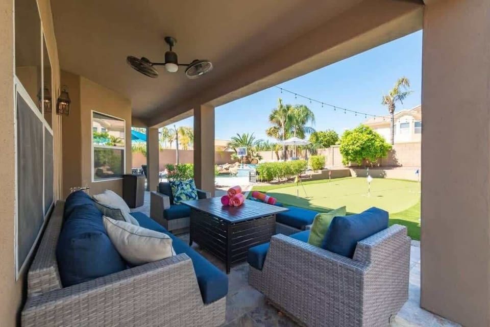Relax in your private covered patio with comfortable seating overlooking the lush backyard and putting green.