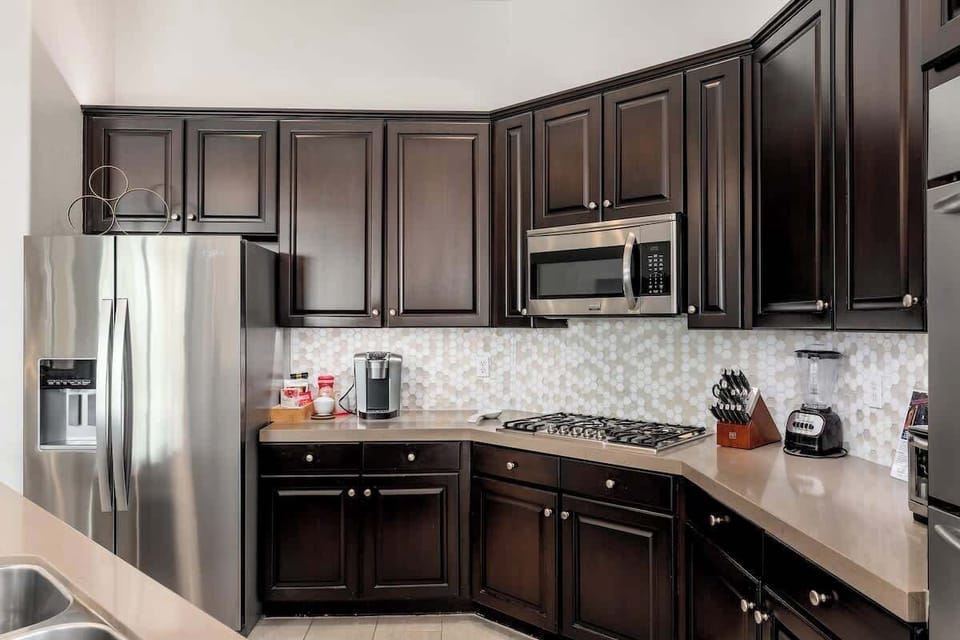 Your fully equipped kitchen invites you to prepare meals with ease, featuring rich cabinetry, modern appliances, and elegant tile backsplash—perfect for gathering over home-cooked favorites.
