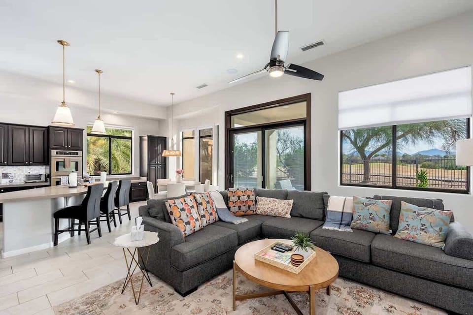 Settle into this bright, open living space where plush seating, natural light, and mountain views create your perfect retreat after exploring the desert surroundings.