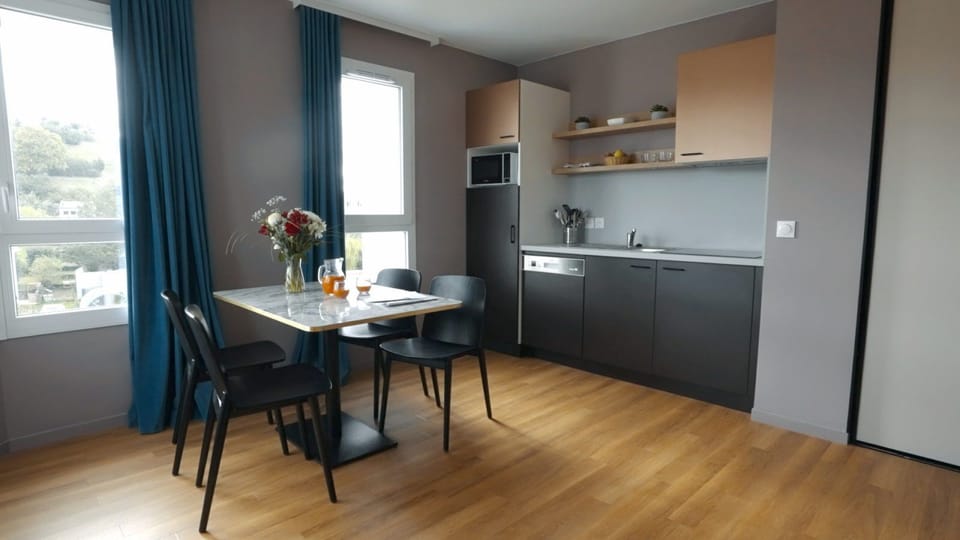 Compact kitchenette with coffee maker, microwave, and dishwasher — everything you need without leaving the apartment
