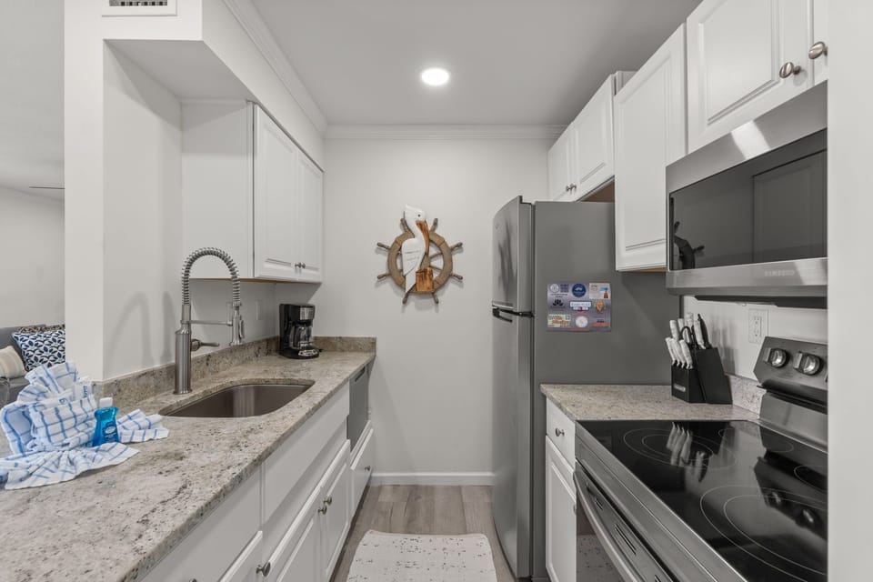 Prepare your favorite meals in this bright, fully equipped kitchen with granite countertops, stainless appliances, and everything you need for a home-away-from-home cooking experience.