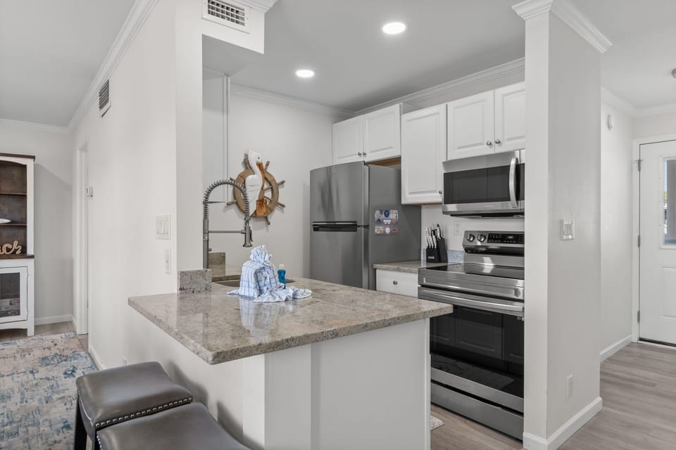 Your fully equipped kitchen features granite countertops, stainless steel appliances, and a central island perfect for preparing meals or enjoying morning coffee together.