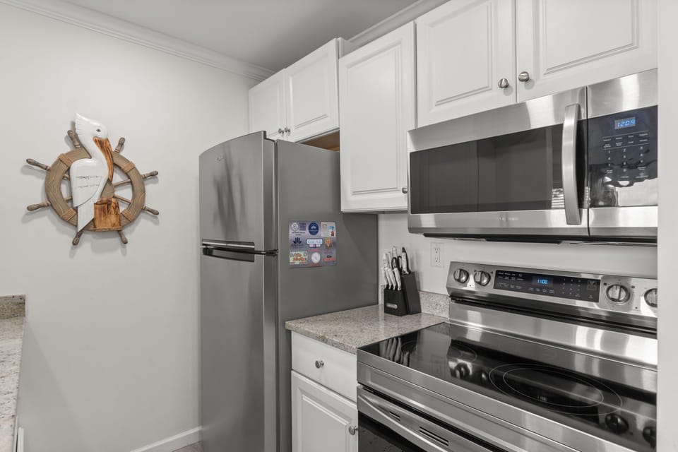 Cook effortlessly in your fully equipped kitchen featuring stainless steel appliances, ample counter space, and coastal charm that makes meal prep feel like a relaxing part of your getaway.