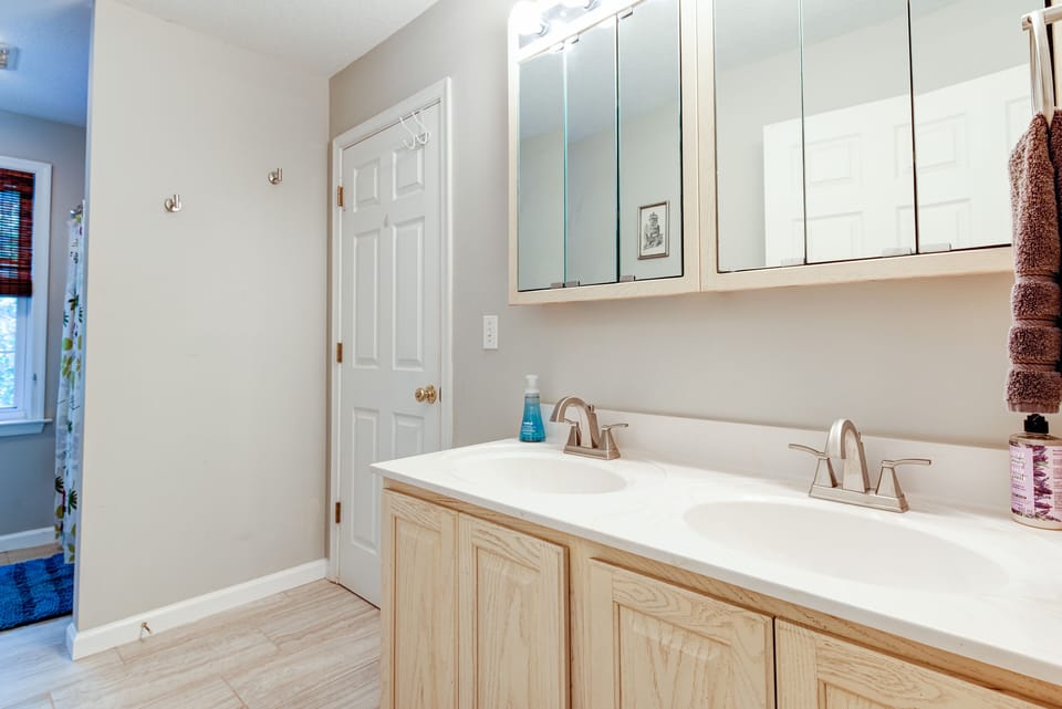 upstairs bathroom with two sinks and shower/bathtub.