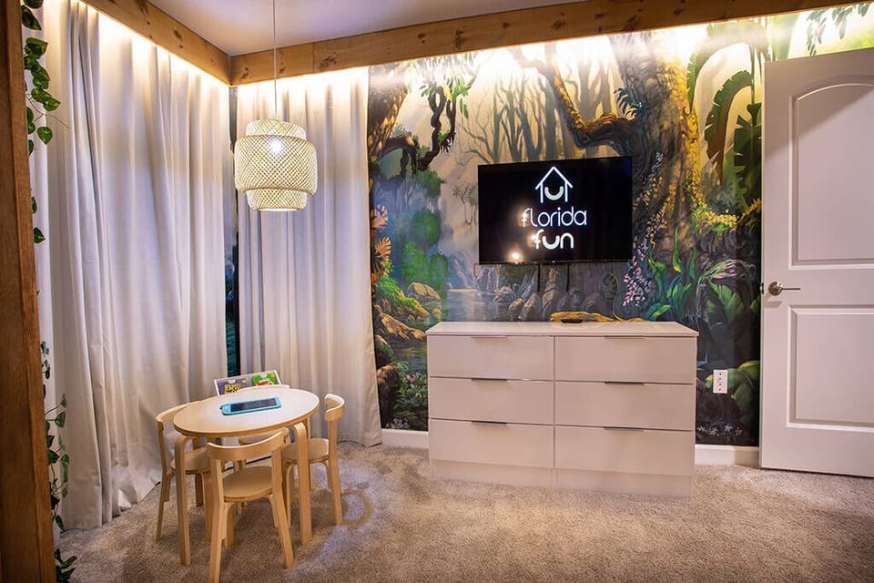 This vibrant room showcases a playful mural that invites nature inside, paired with soft, neutral tones. A stylish light fixture above a charming children's table creates a cozy corner ideal for relaxation or playtime.