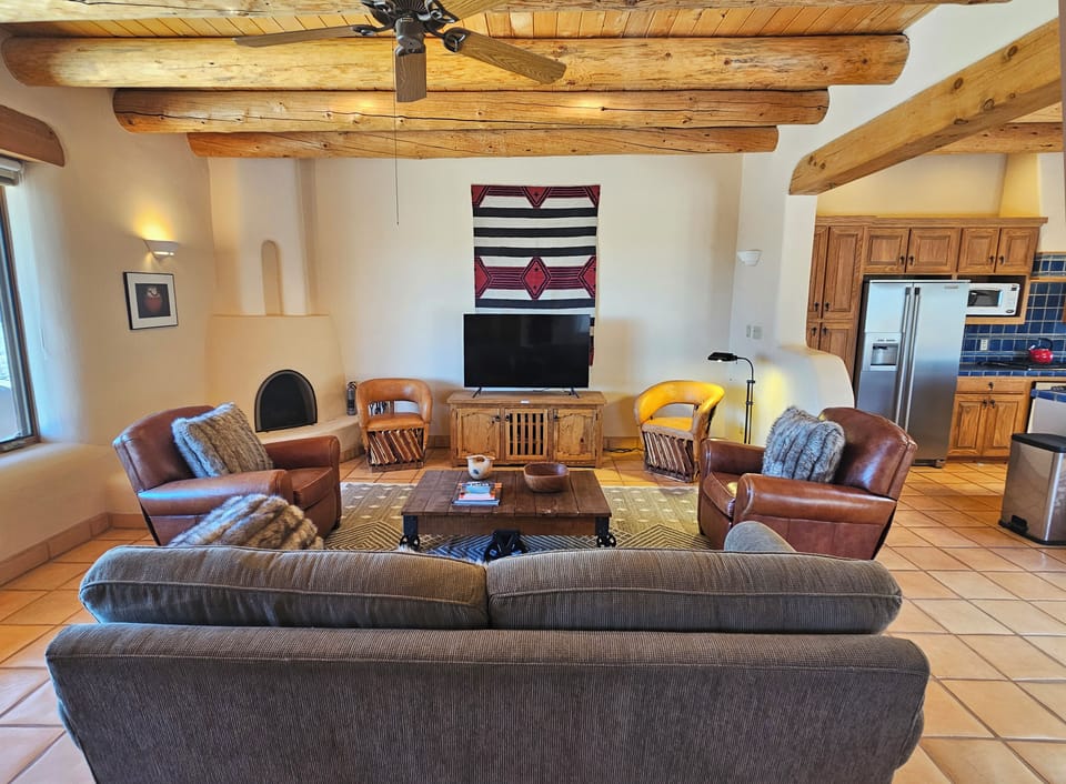 Livingroom with candle only kiva fireplace and large Smart TV.