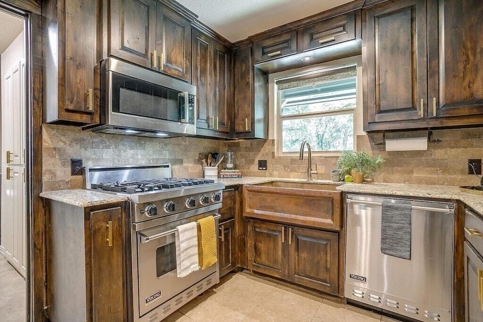 Viking range, farmhouse sink, and custom cabinetry in the Bougie Bungalow kitchen. A design-forward vacation rental in Keller, Texas, where the interior matches the energy of the outdoor spaces.