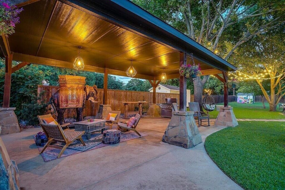 The covered pavilion at golden hour. A hot tub, string lights, and global decor make this one of the most design-forward outdoor living spaces in the Keller and Southlake area.