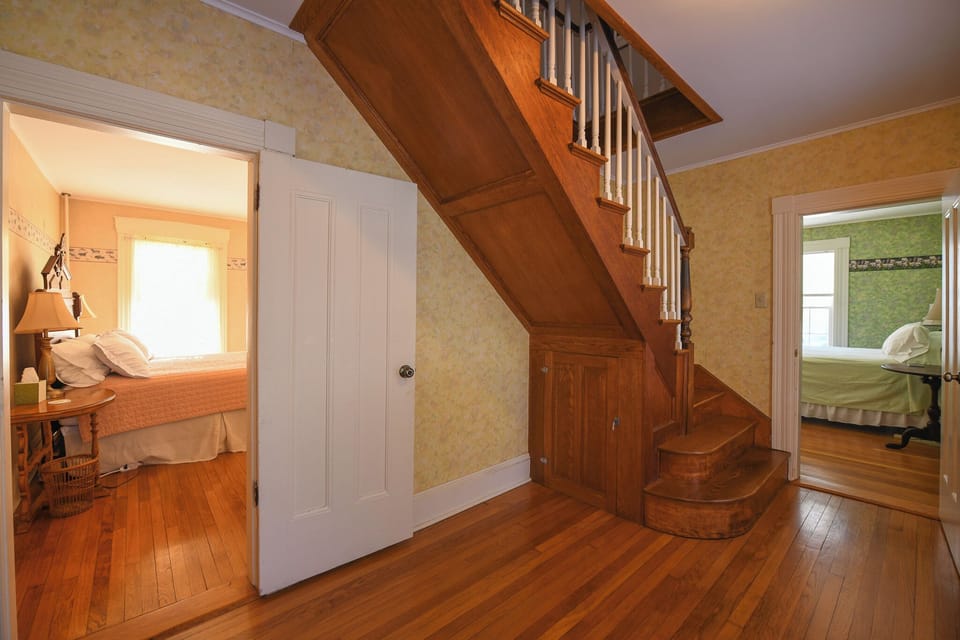 Front downstairs hallway leading to two bedrooms and stairs to upstairs bedrooms