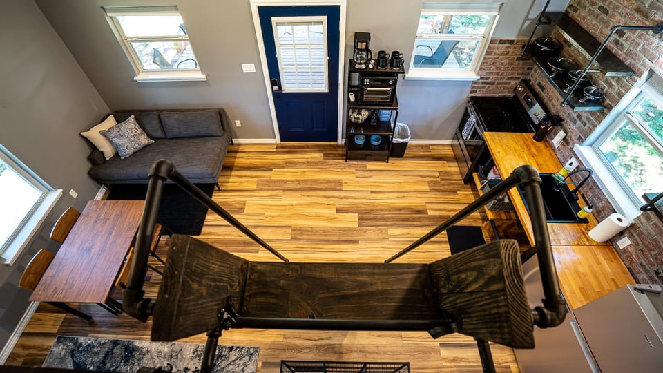open concept dining, kitchen, living space from vaulted loft view. 
