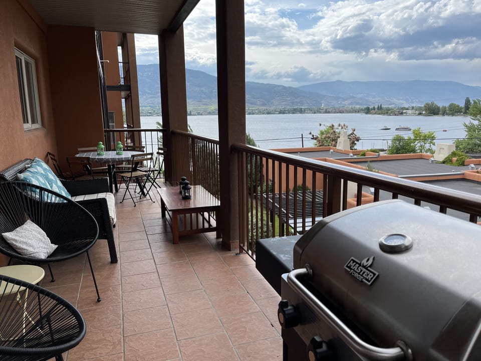Large covered balcony with patio furniture, dining table and gas bbq