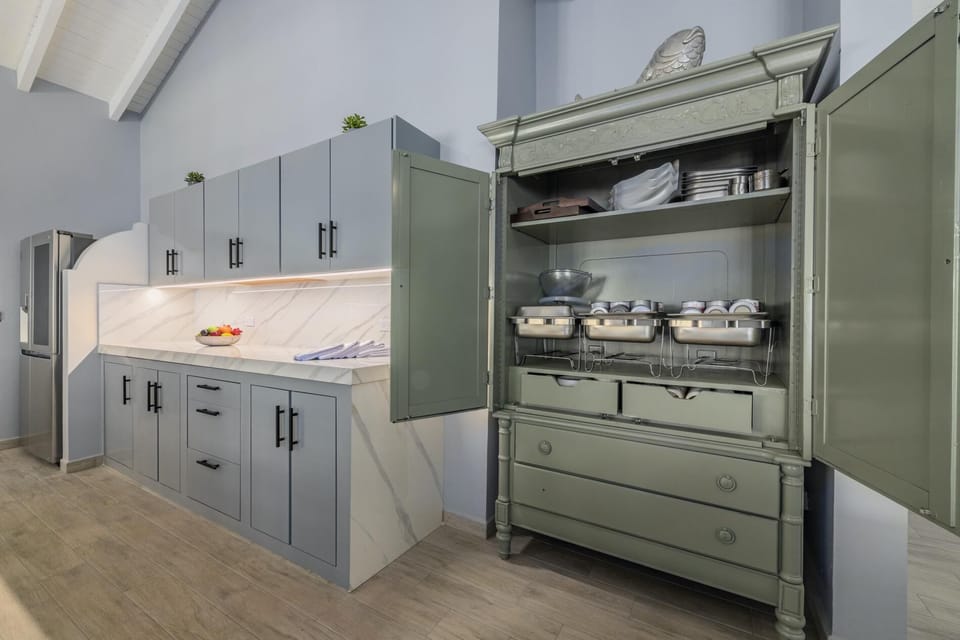 This dining and kitchen area has an elegant color interior.  There is plenty of storage space in the full kitchen. There is an 8-seater table and cushioned chairs in the dining area.