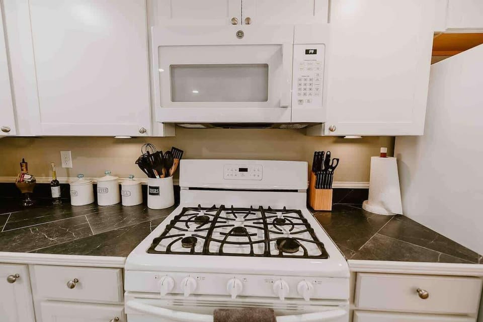 Fully equipped kitchen featuring an oven with a gas stove, microwave, refrigerator with a freezer, and a dishwasher. Everything you need for a comfortable stay and easy meal prep.