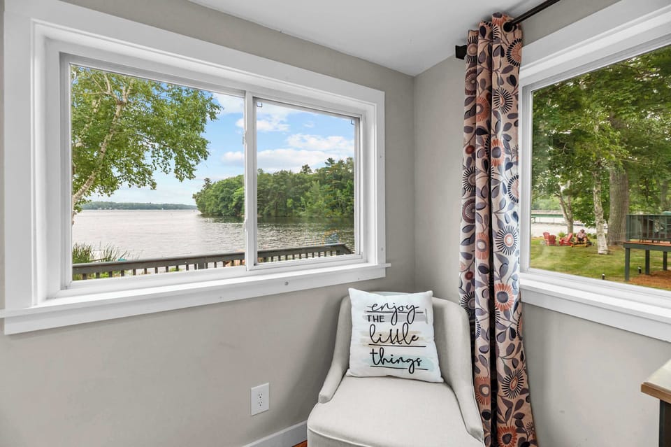 Beautiful lake views right from the cottage—large windows bring Cobbosseecontee Lake and the surrounding greenery into the living space.