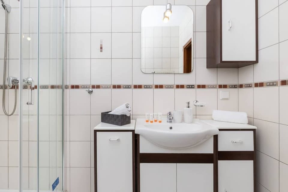 Bright bathroom with washing machine and shower cabin. 
