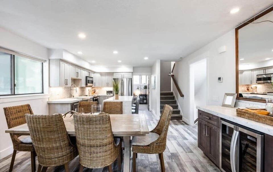 The dining space features a table with seating for six, but also boasts a bar area with a wine fridge for easy serving while you dine. This view shows its convenient location near the kitchen.