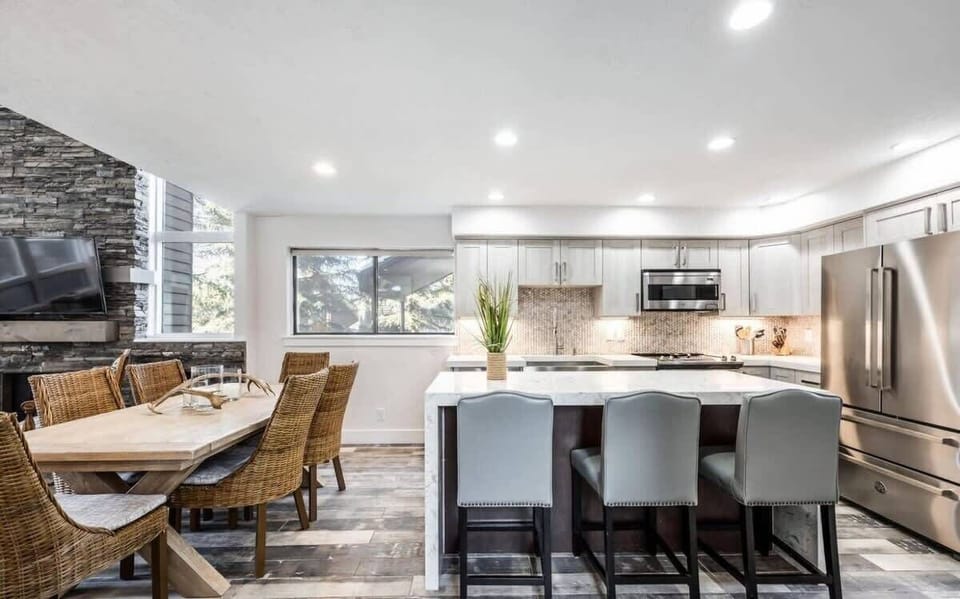 The fabulous open-concept layout in this home makes for easy movement between the kitchen, dining and living areas. Here you see the dining table for six and the waterfall island that seats three in the gorgeous kitchen.