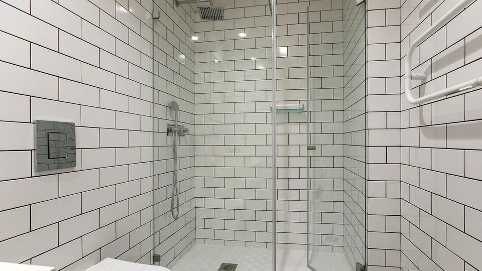 Step into the spacious, tiled shower with modern fixtures, offering a refreshing start or end to your day.
#Bathroom #WalkInShower #ModernDesign #LovelyStay