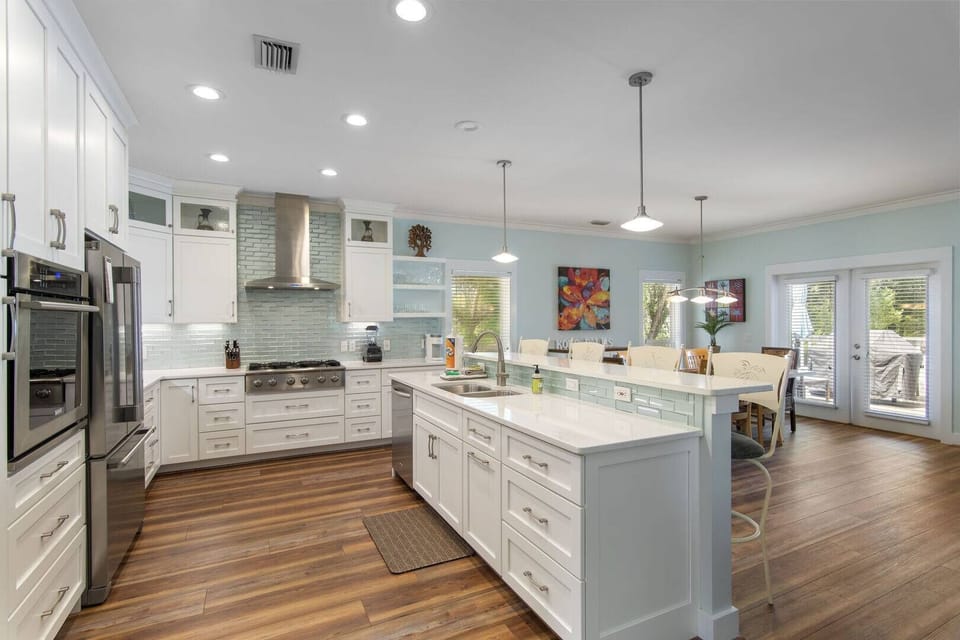 Spacious kitchen w/ island, modern appliances & warm wood floors