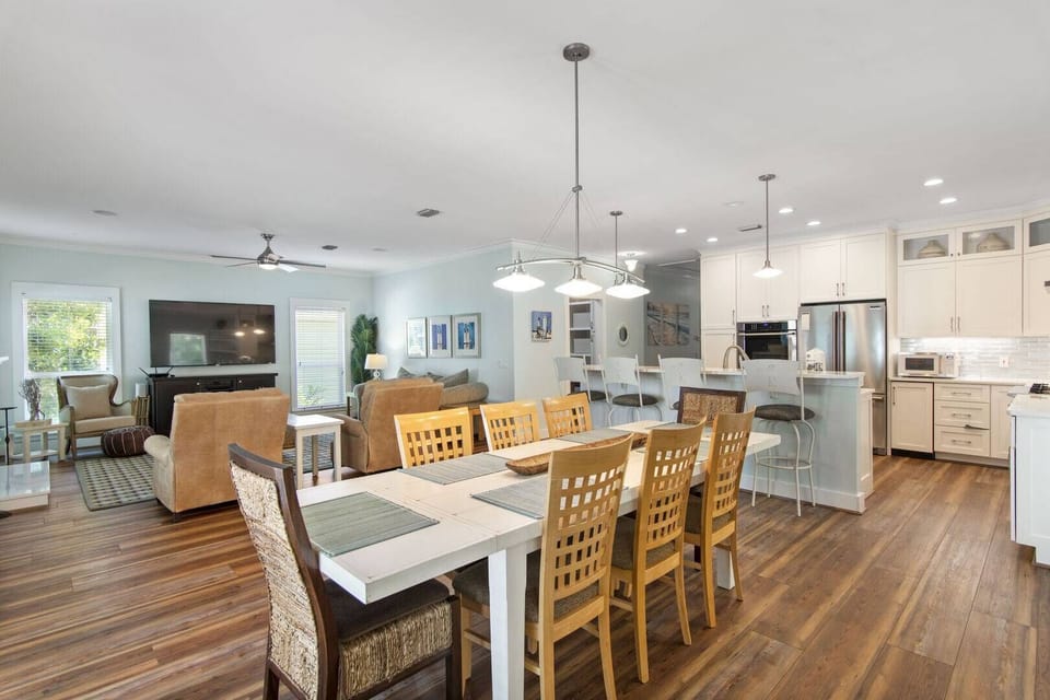Open dining area w/ farmhouse table beside the kitchen
