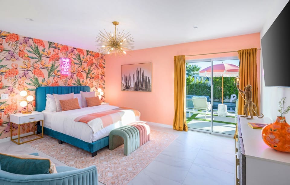 Primary suite with king bed, flamingo wallpaper, and private patio doors