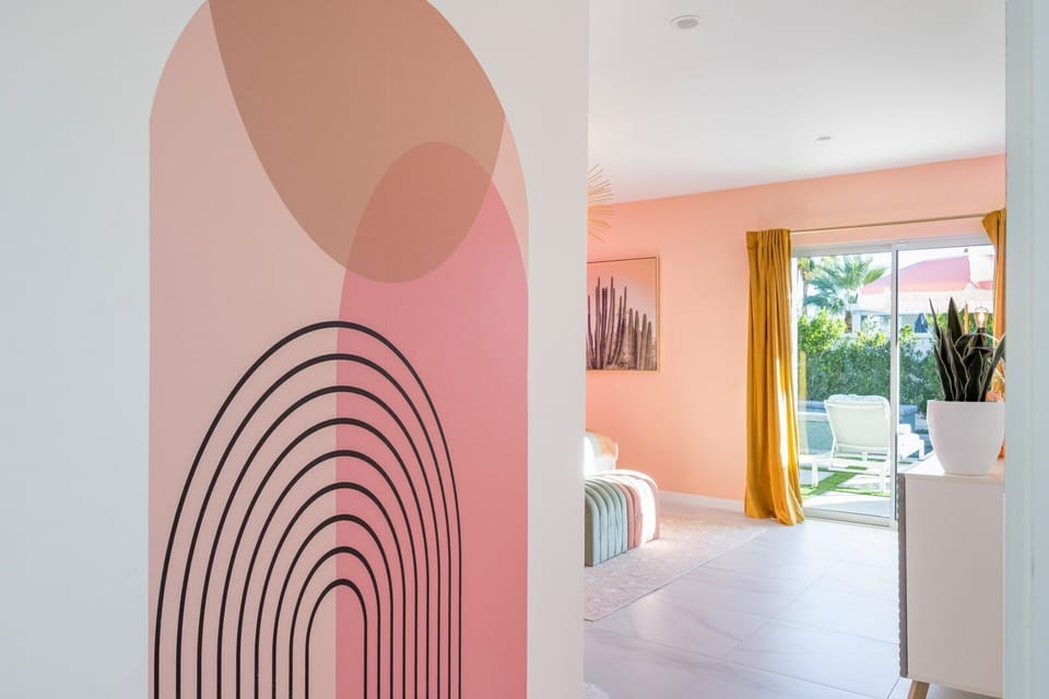 Designer mural hallway leading to primary suite with backyard access