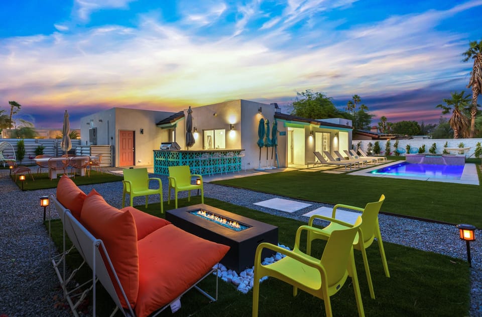Backyard at sunset with fire pit, pool lighting, and evening ambiance