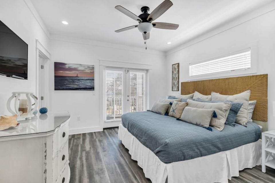 Airy bedroom w/ cozy textures, ceiling fan & soft natural light.