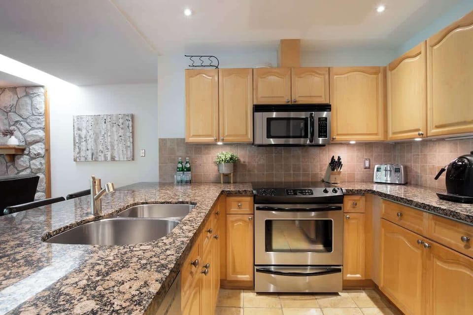 - Modern kitchen with granite counters and stainless-steel appliances  
- Fully equipped for home cooking and extended stays in style  
- Enjoy a seamless flow from kitchen to living and dining area  
