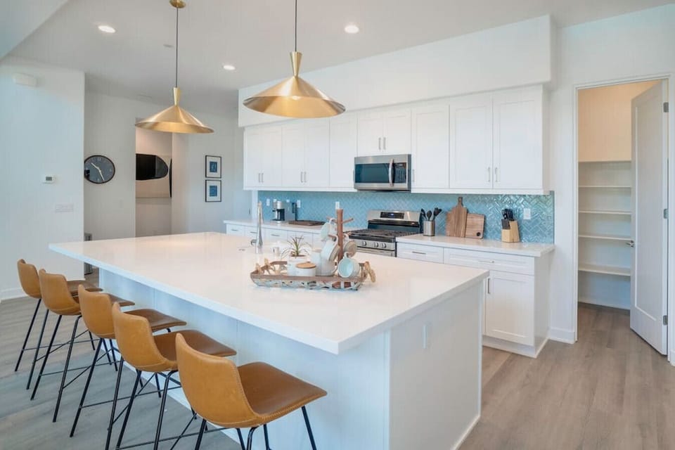 Modern kitchen w/ oversized island, bar seating & sleek finishes for easy gatherings