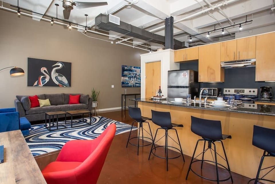 Relax in this cozy, modern living room featuring chic décor, comfortable seating, and warm lighting that creates the perfect ambiance for unwinding in the heart of downtown Fort Worth.