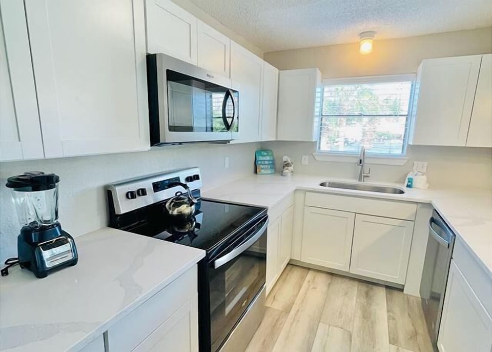 Your bright, fully equipped kitchen invites culinary creativity with modern appliances, crisp white cabinets, and plenty of prep space.