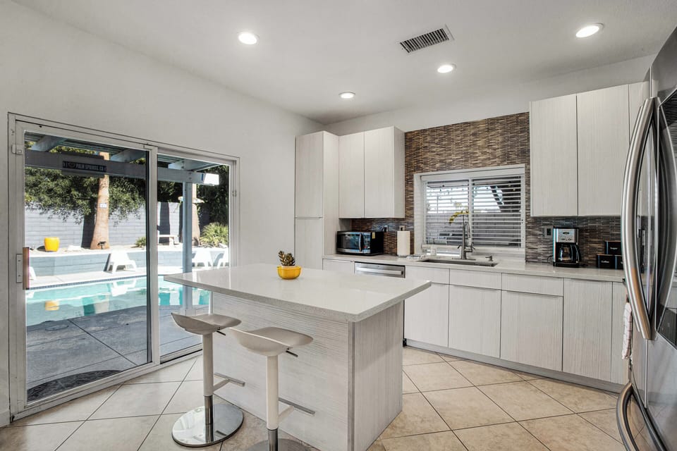 Open kitchen with island seating and a clear view of the pool
