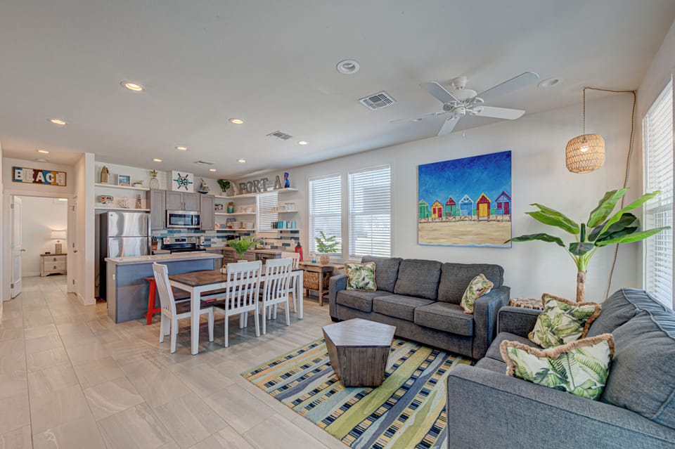 Your coastal haven features an open-concept living space where beach vibes meet comfort—relax on plush sofas while tropical artwork sets the mood.