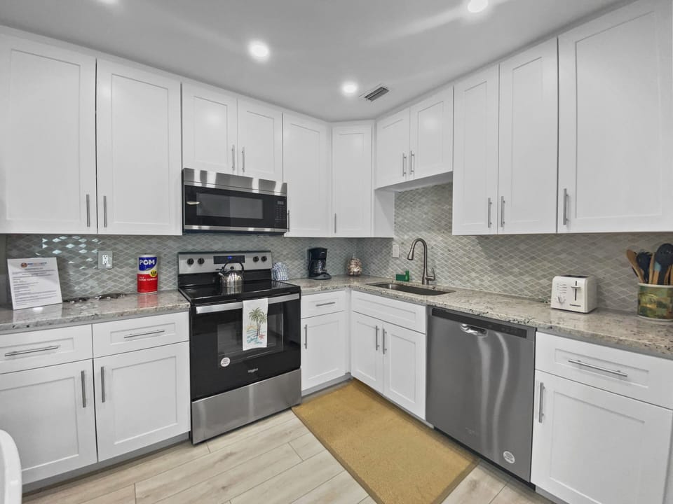 Kitchen view showing stainless range, dishwasher, and tile backsplash