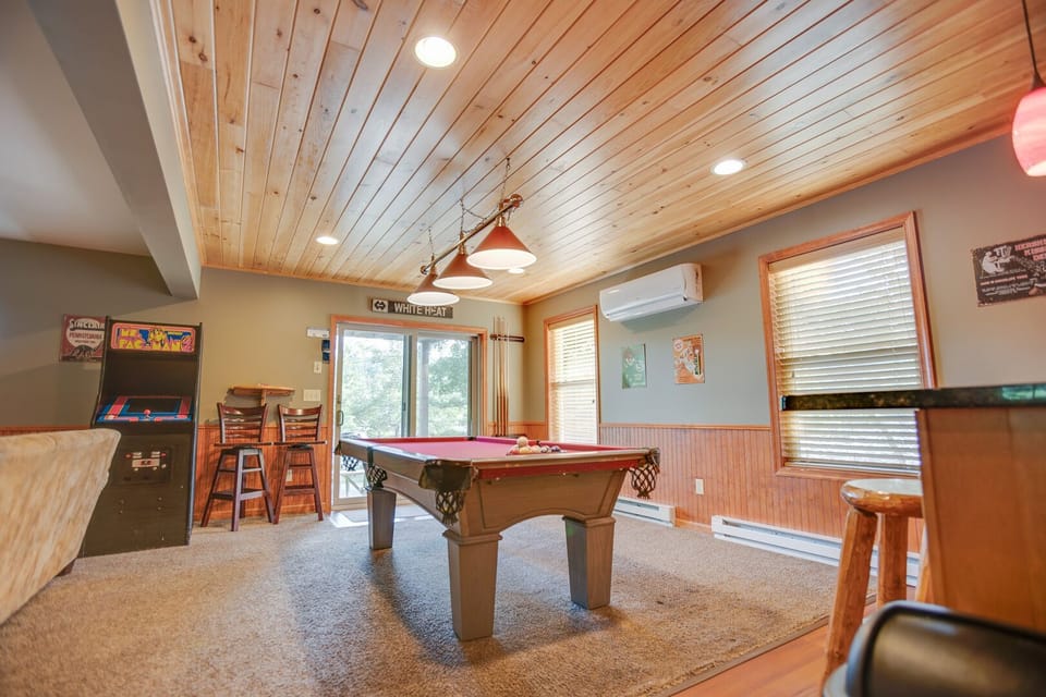 There is a ton of fun to be had in this game room w/ an arcade machine, pool table, bar top, and large Smart TV!