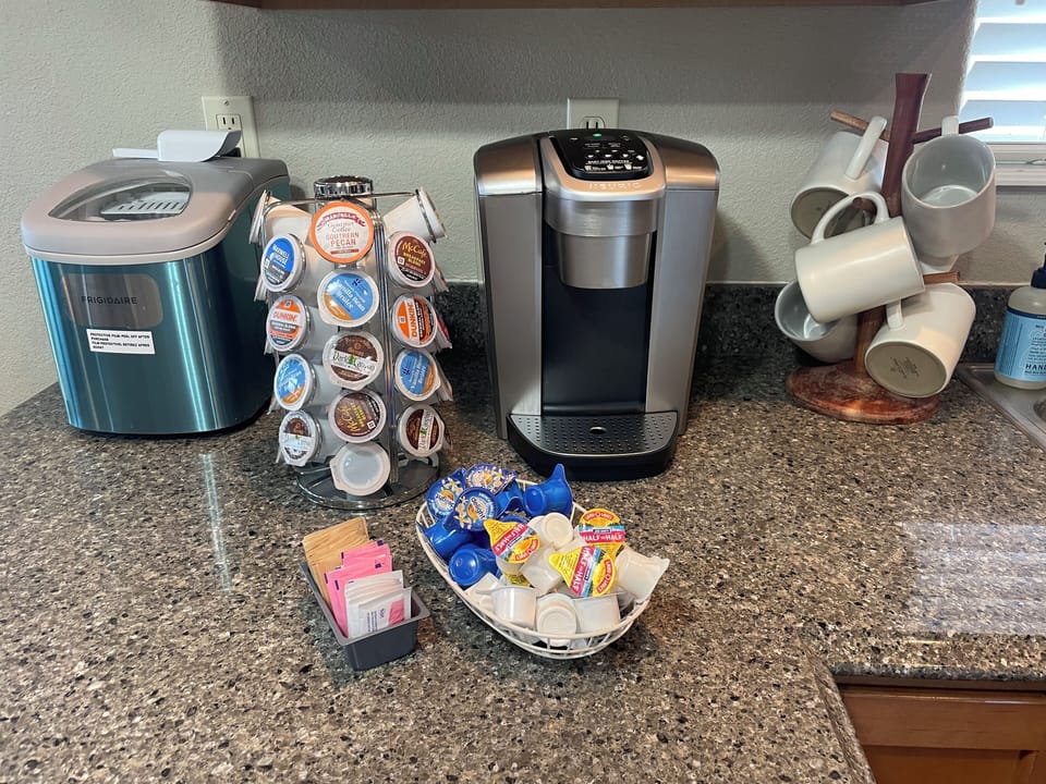 Keurig, coffee pods, cream & sugar, mugs & an ice maker.
