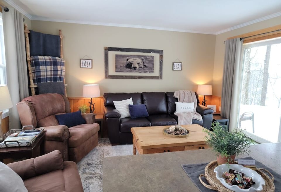 Leather sofa, 2 recliners & plush blankets in the living room with lake views