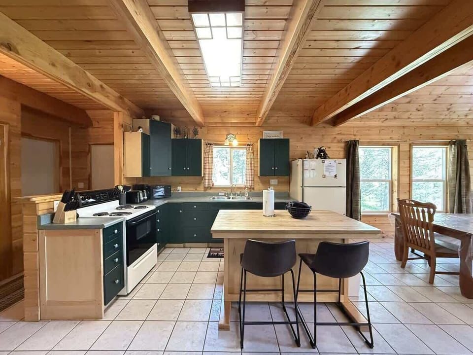 Full kitchen with island to prepare food. Appliances, basic spices, dishes, and silverware are provided.