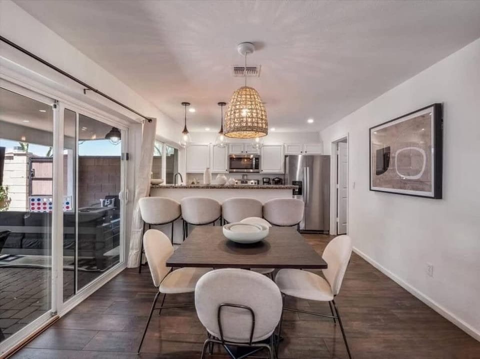 Step into your sleek, open-concept space where modern design meets comfort. Sunlight pours through sliding doors, inviting you to relax at the stylish dining table or unwind in your fully equipped kitchen.