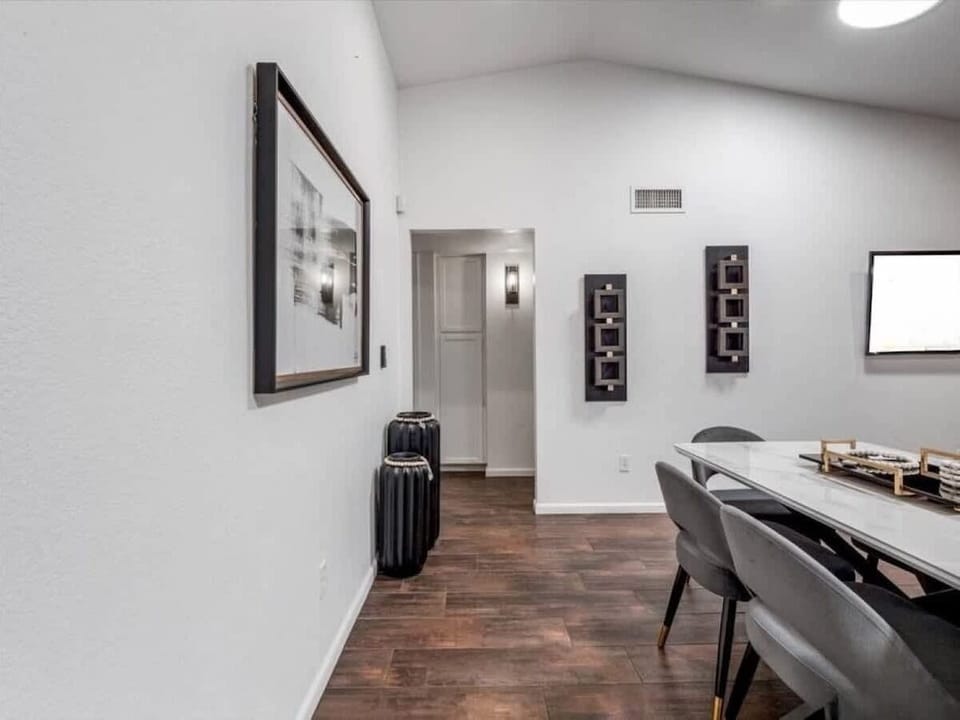 Drop your bags and step into your stylish retreat. This elegant entryway welcomes you with modern art, warm wood floors, and a cozy dining space ready for memorable meals together.