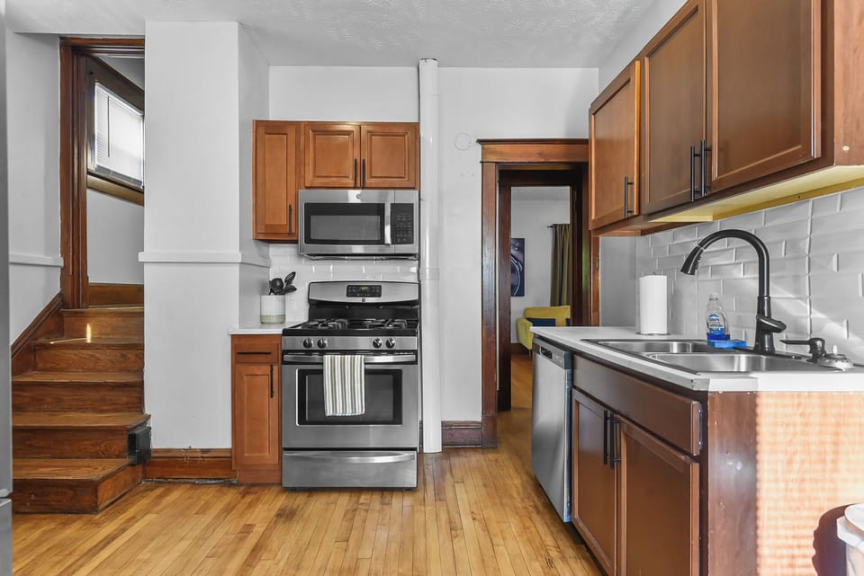Your fully equipped kitchen features warm wood cabinets, stainless steel appliances, and elegant subway tile backsplash for memorable meal preparation.