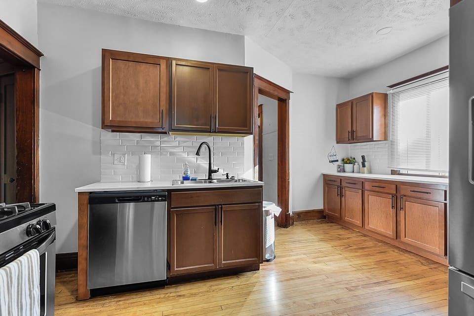 Cook your favorite meals in this fully equipped kitchen with rich wood cabinets, sleek appliances, and a charming subway tile backsplash.