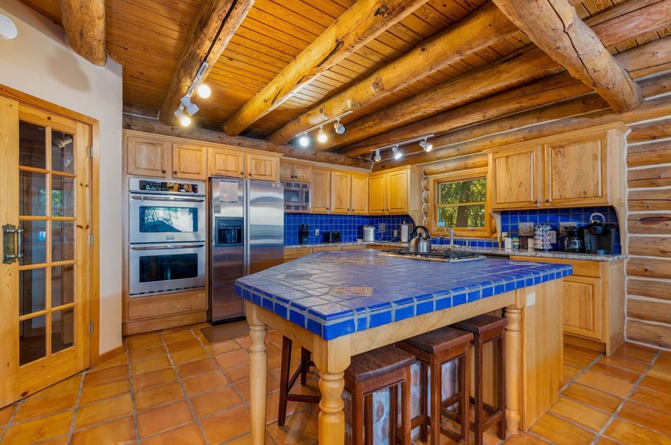 Fully stocked kitchen with a blender, coffee pot, toaster, ice maker, double oven, microwave, pots, pans, dishes, utensils, and plenty of space to feed a crowd. 