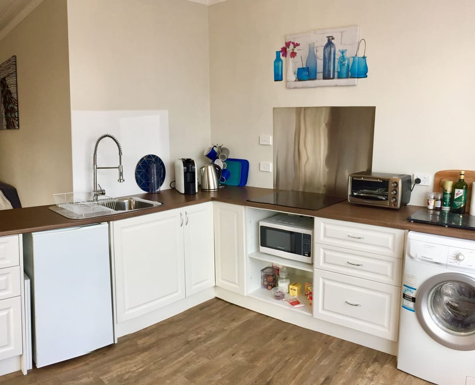 Kitchen with all the amenities, cooktop, fridge, microwave, coffee machine