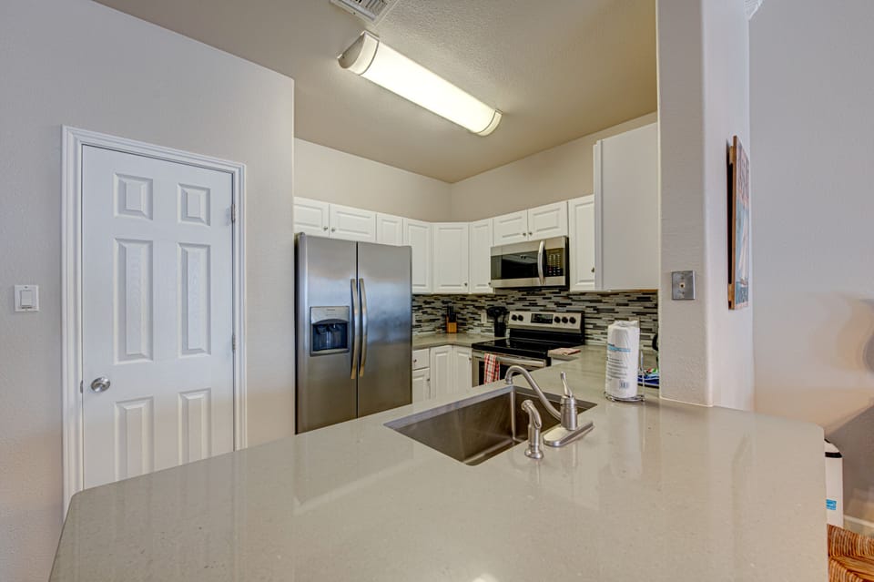 Your fully-equipped kitchen awaits with gleaming countertops, stainless steel appliances, and everything you need to create memorable meals during your stay.